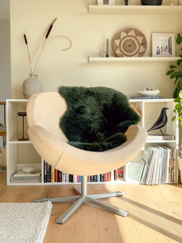 Green sheepskin rug on wooden floor in minimalist living room